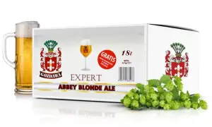 Zestaw do warzenia piwa z brewkitu "Abbey Blonde Ale" z chmielem gratis. Obok kartonu kufel złocistego piwa i świeże szyszki chmielu.