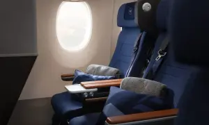Lufthansa Premium Economy Sitze mit Kissen und Decken neben einem Fenster.