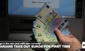 Ręka trzyma banknoty 20 euro przy bankomacie. Bułgarzy po raz pierwszy wypłacają nową walutę.