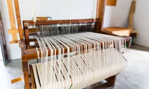 Telai in legno con fili bianchi pronti per creare tessuti come quelli del Medioevo.