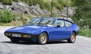 Blå Matra Bagheera sportbil parkerad vid en bergssluttning med grönska.