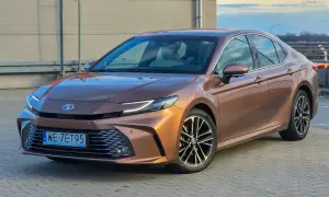 Brązowa Toyota Camry 2.5 Hybrid lśni w słońcu, gotowa na podróż.