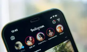 Telefon z otwartym Instagramem, pokazujący profile znajomych. Dowiedz się, jak udostępnić czyjąś relację na swoim IG.