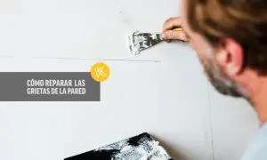 Hombre aplicando masilla para reparar grietas en la pared. Guía visual sobre cómo reparar grietas en la pared.