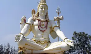 Stor staty av Shiva, en viktig gudom inom hinduismen, sitter i meditation med en orm runt halsen och en treudd i handen.