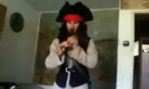 Osoba w stroju pirata z Karaibów gra na flecie.