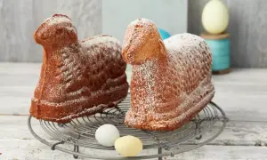 Zwei goldbraune Osterlämmer, mit Puderzucker bestäubt, auf einem Gitter. Ein perfektes Osterlamm Rezept für das Fest.