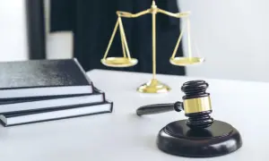 Młotek sędziowski, waga sprawiedliwości i stos ksiąg prawnych symbolizują sprawiedliwość i procesy, w tym zrzeczenie się spadku.