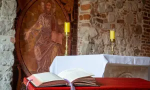 Ołtarz z otwartą księgą, świecami i mozaiką Chrystusa. Ilustruje etapy rozwoju wiary według psychologii rozwojowej.