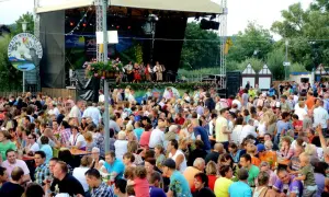 Menschen feiern beim Weinfest Sand am Main. Eine Band spielt auf der Bühne, während Gäste an Tischen sitzen und die Atmosphäre genießen.