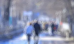 Rozmyty tłum ludzi na ulicy, jakby patrzyli przez szkło z podwójnym widzeniem z daleka.