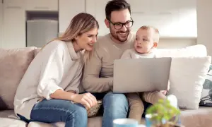 Rodzina ogląda coś na laptopie, zastanawiając się, czy 800 plus wlicza się do dochodu.