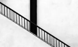 Ringhiera nera su muro bianco, un elemento essenziale per un montascale per anziani, agevolazioni per una vita più serena.