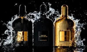 Trzy flakony perfum Tom Ford Black Orchid, w tym jeden złoty, otoczone wodnymi rozpryskami. Wyczuwalna nuta wanilii.