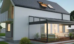 Modernes Haus mit Glas-Wintergarten, der zum **Wintergarten selber bauen** einlädt. Gemütliche Sitzmöbel laden zum Verweilen ein.