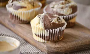 Saftige Marmor Muffins mit einem Swirl aus hellem und dunklem Teig, serviert auf einem Holzbrett.