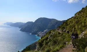 Escursionisti sul Sentiero degli Dei, con vista mozzafiato sulla costa amalfitana e il mare blu intenso.