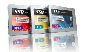 Trzy dyski SSD: 480GB, 1TB i 2TB, z odbiciami. To nowoczesne nośniki danych.