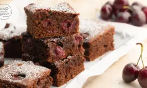 Saftiger Schoko Kirsch Kuchen vom Blech, bestäubt mit Puderzucker. Kirschen und Schokolade vereinen sich zu einem köstlichen Genuss.
