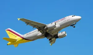 Samolot Germanwings z żółtym ogonem wznosi się na tle błękitnego nieba.