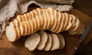 Czerstwy chleb pokrojony w kromki na desce. Świetny pomysł, co zrobić z czerstwego chleba, to grzanki lub bułka tarta.