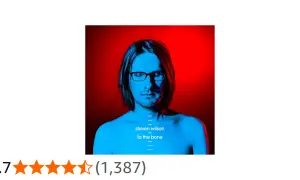 Steven Wilson w okularach, z niebieskim światłem na twarzy i czerwonym tle. Tytuł albumu: "To the Bone".