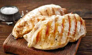 Petto di pollo alla griglia, perfetti secondi di carne da preparare in anticipo. Un contorno di sale completa l'immagine.