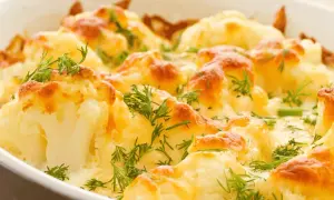 Coliflor al horno gratinada con queso y hierbas frescas, un plato reconfortante y delicioso.