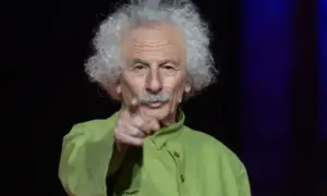 El brujo del Teatro de las Esquinas, con su melena blanca y camisa verde, señala al público.
