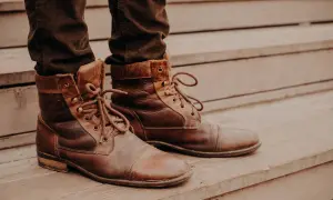 Brązowe, sznurowane buty na drewnianych schodach. Idealne do ozonowania butów, by odświeżyć je po długim dniu.