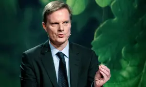 Jens Henriksson, VD för Swedbank, talar med en gest. Bakgrunden är grön med stora blad.