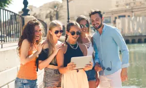 Grupa przyjaciół śmieje się, patrząc na tablet. Widać, że to prawdziwy ekstrawertyk, kto to potrafi rozbawić wszystkich wokół!