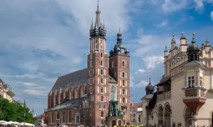 Majestatyczna Bazylika Mariacka w Krakowie góruje nad Rynkiem Głównym, gdzie tętni życie.