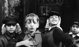 Quattro bambini con berretti, uno sorride, uno parla. Un'istantanea che cattura l'essenza della vita di strada, degna dei **best photographers**.