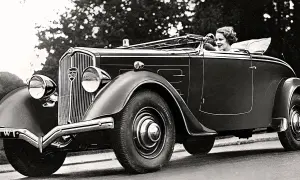 En kvinna kör en elegant cabriolet, ett exempel på gamla bilmodeller från 1930-talet.
