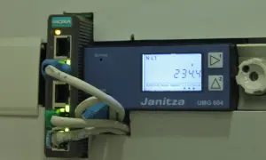 Urządzenie Janitza UMG 604 z modułem MOXA zbiera dane, umożliwiając telemetrię. Na ekranie widoczny pomiar napięcia 234.4V.