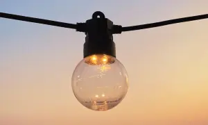 Guirlande lumineuse extérieure, une ampoule sphérique éclairée sur fond de ciel crépusculaire. La définition IP protection garantit sa résistance.