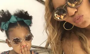 Mała córka Beyoncé w okularach w kształcie kwiatków i zielonej kokardce, obok mamy w okularach z ozdobnymi oprawkami.