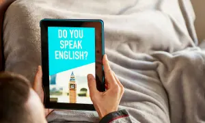 Osoba korzysta z aplikacji do nauki angielskiego na tablecie. Na ekranie widnieje pytanie "DO YOU SPEAK ENGLISH?" i miniatura Big Bena.