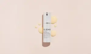 Siero ELEMIS con acido glicolico e vitamina C, per una pelle luminosa e rinnovata, circondato da gocce dorate.