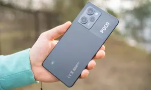 Dłoń trzyma ciemnoszary telefon POCO X5 5G z modułem aparatów i logo POCO.