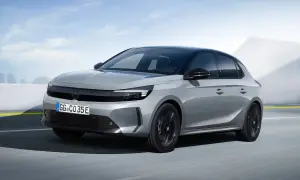 Grå Opel Corsa-e testkörs på en väg med en modern bakgrund.