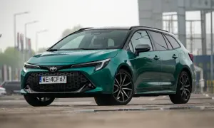 Nowa Toyota Corolla 2025 w kolorze zielonym, z czarnym dachem i felgami, prezentuje się stylowo na mokrej nawierzchni.