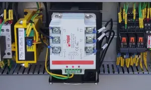 Wewnątrz szafy sterowniczej widoczny jest trójfazowy przekaźnik SSR marki Relpol, otoczony przewodami i innymi elementami elektrycznymi.