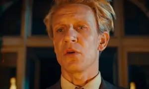 En man med blont hår och en grå kostym, med en blick som säger "och så var de bara en".
