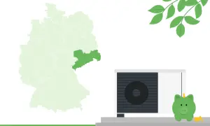 Sachsen hebt sich auf der Deutschlandkarte ab. Eine Wärmepumpe und ein Sparschwein deuten auf das neue Heizungsgesetz hin.