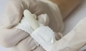Ręce w rękawiczkach trzymają biały, torpedowy czopek.