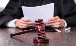 Sędzia w todze czyta dokument, obok młotek. Ile sąd ma na uzasadnienie wyroku?