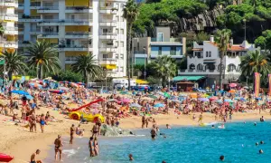 Lloret de Mar pogoda kwiecień: plaża pełna ludzi, słońce, palmy i turkusowe morze. Idealny dzień na wypoczynek.