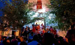 Multitud reunida frente a una iglesia iluminada, disfrutando de las fiestas de Calatayud.